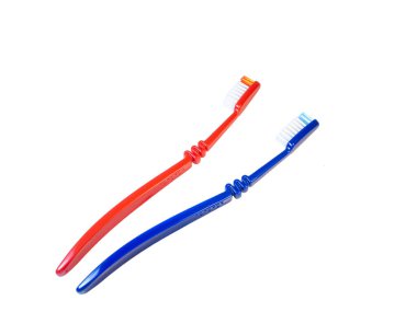 Beyaz arka planda iki diş fırçası var. Mavi ve kırmızı diş fırçası