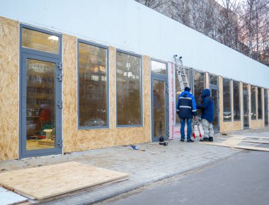 Merdivenli işçiler. Ticaret pavyonunun dış dekorasyonu