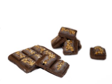 Beyaz arka planda fındıklı sütlü çikolata. Çikolata piramidi. Çikolata dilimi