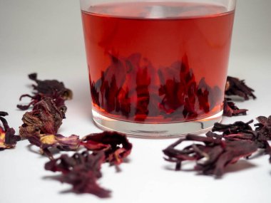  Karkade. Bardakta çay içiyorum. Bardakta kırmızı sıvı. Kurumuş taç yaprakları. Hibiscus. Sudan gülü