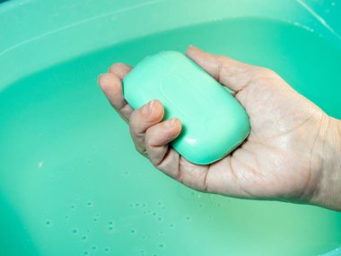 El yıkama. Elinde tuvalet sabunu var. Yeşil sabun. El yıkama. Hijyen