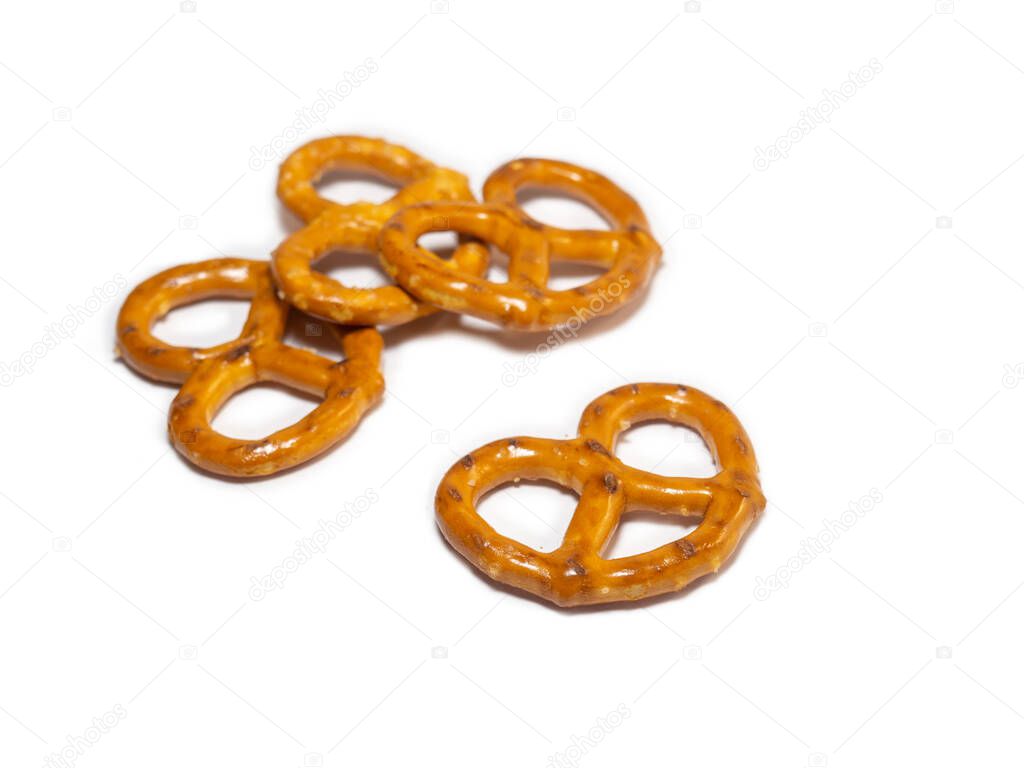 Small pretzels on a white background. Flour products. Baking for tea. Crispy biscuits.A bunch of pretzels. Lots of pieces.Pastries of an interesting unusual shape.