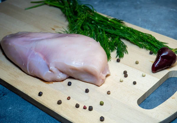 Filé Peito Frango Uma Tábua Corte Fundo Preto Pimenta Pimenta — Fotografia de Stock