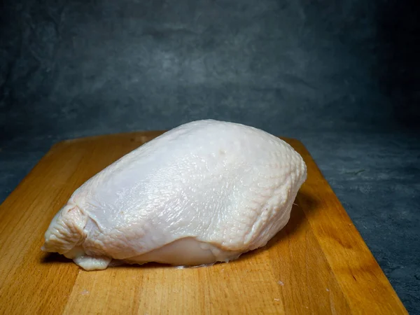 Kesme Tahtasında Derisi Olan Bir Tavuk Göğsü Siyah Arka Planda — Stok fotoğraf