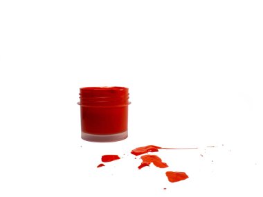 Beyaz arka planda kavanozda kırmızı akrilik. Masaya boya damlaları. renk