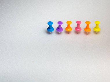 Renkli hatıra raptiyeleri. Beyaz arka planda kırtasiye malzemesi. Ofis için gerekli