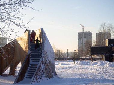 Kış kenti parkında olağandışı bir kayma. İnsanlar kızakla kayıyor.