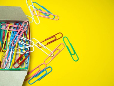 Kağıt üzerinde renkli ataçlar. Ofis malzemeleri. İş eşyaları. Renkli ofis malzemeleri