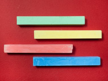 Kırmızı arka planda renkli boya kalemleri. Aksesuar çiziyorum. Sanatçı Aracı