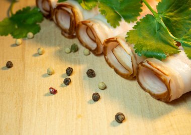 Kıvrımlı kesikler rulo şeklinde katlanmış. Maydanozlu mutfak tahtasındaki domuz eti. Etten bir hayat. Domuz eti iştah açıcı.