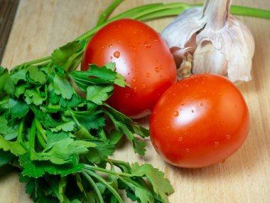 Mutfak tahtasına maydanozlu erik domates ve sarımsak. Sebzeli sebzeler. taze sebze.