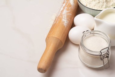 Pişirmek için malzemeler. un, yumurta, merdane, çırpı, kaşık, ahşap zemin