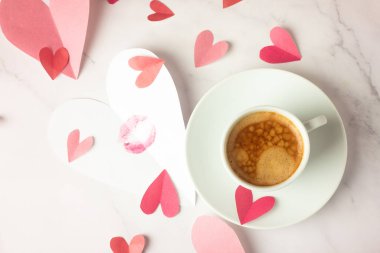 bir fincan sade kahve ve bir sürü kağıt kalp ve boşluk.