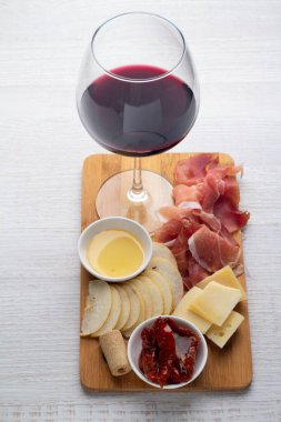 Bir bardak kırmızı şarap ve atıştırmalık beyaz bir çiftlikte