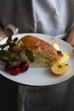 Çocuk sana yakın bir tabak elmalı turta tutuyor.