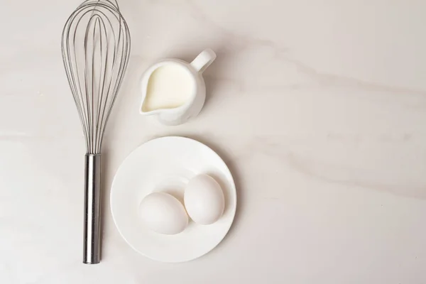 Beyaz arkaplanda yumurta ve un çırpın