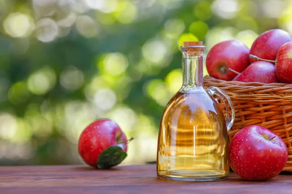 Яблочный уксус или сидр в стеклянной бутылке на открытом воздухе — стоковое фото