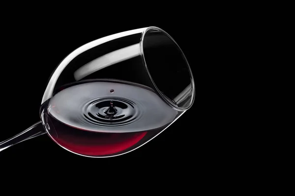 Капля красного вина падает в стакан и создает всплеск — стоковое фото