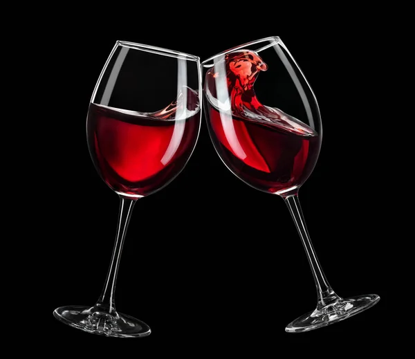 Two glasses of red wine toasting isolated on black — Stock Photo, Image