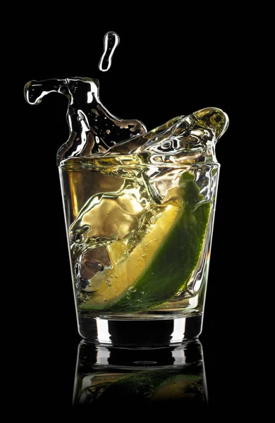 Gold tequila shot with lime slice and splash — Stock Photo, Image