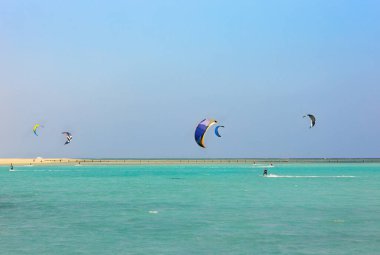 Uçurtma sörfü için renkli uçurtmalar mavi gökyüzünde uçuyor