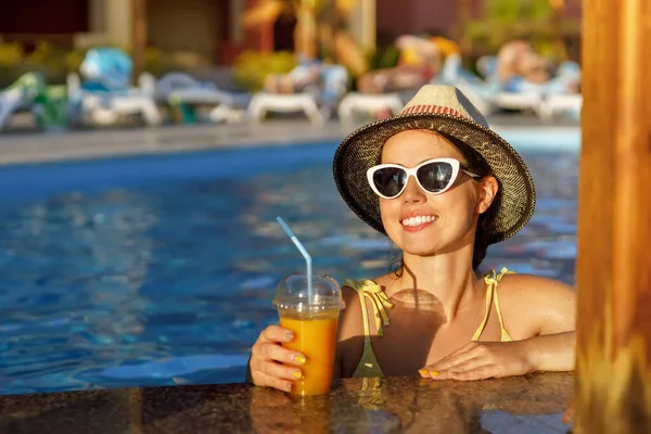 Gülümseyen kadın bilardo barında kokteyl içiyor.