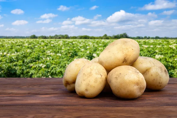 Heap Young Potatoes Wooden Table Blooming Field Blue Sky Background — ストック写真