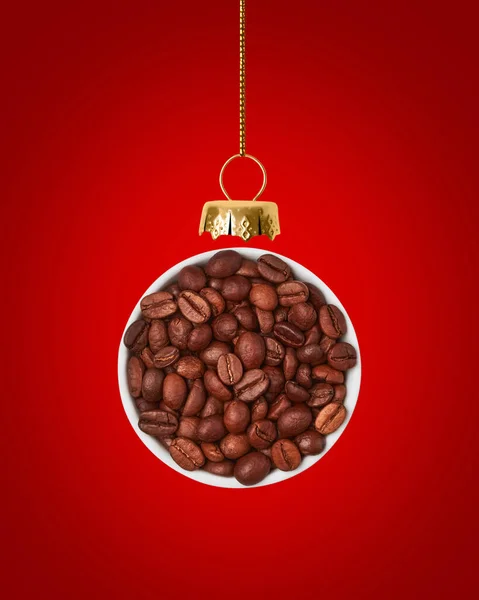 Świąteczna piłka wykonana jest z ziaren kawy na czerwonym tle. — Zdjęcie stockowe