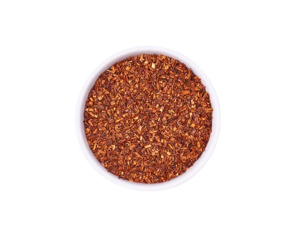 Beyaz arka planda izole edilmiş beyaz kâsede kurutulmuş rooibos çayı. Sağlıklı içecek..