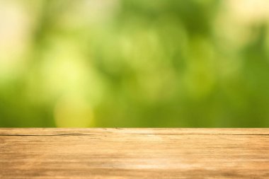 Yeşil bulanık arkaplanda boş tahta masa