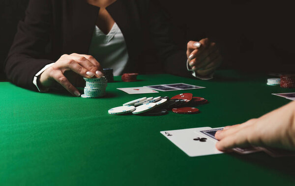 Woman plays poker. Focus on the center of table.