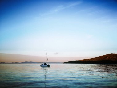 Durgun bir yaz gecesinde cennette gün batımına yelken açarak.