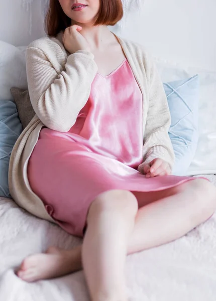Ung Kvinna Sidenrosa Pyjamas Och Vit Kofta Poserar Sängen Foto — Stockfoto