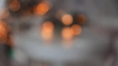 Yeni yıl dekoru yemek masasında. Masaya Noel ağacı dalları ve parlayan toplardan oluşan bir çelenk konmuş..