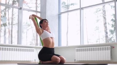 Genç, güzel bir kadın ya da kız odada yoga egzersizleri yapıyor. 