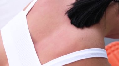 Spor yaptıktan sonra kasları gevşetmek için köpük silindiri kullanan kız