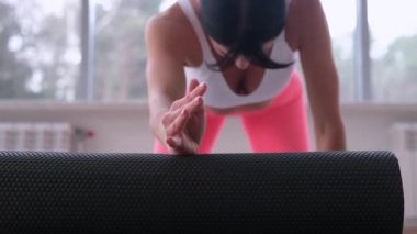 Spor yaptıktan sonra kasları gevşetmek için köpük silindiri kullanan kız