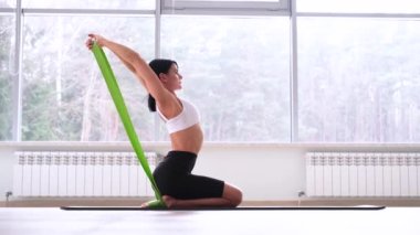 Genç, güzel bir kadın ya da kız odada yoga egzersizleri yapıyor. 
