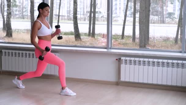 Athletic girl lunges against a big window — Stockvideo