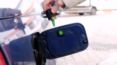 Woman hand closing the oil filler cap at the gas station