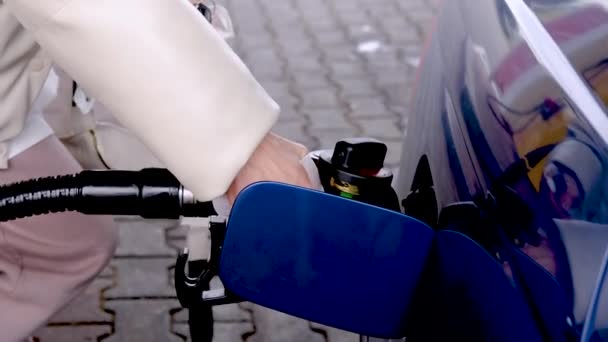 Close-up of a female hand inserting a gas nozzle into the tank. — Stockvideo