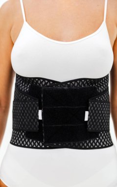 İnsan vücudunda ortopedik bel korsesi. Sırt desteği, bel destek kemeri. Sırt köprücük kemiği için duruş düzelticisi. Ameliyat sonrası fıtık, hamilelik ve doğum sonrası bel desteği..