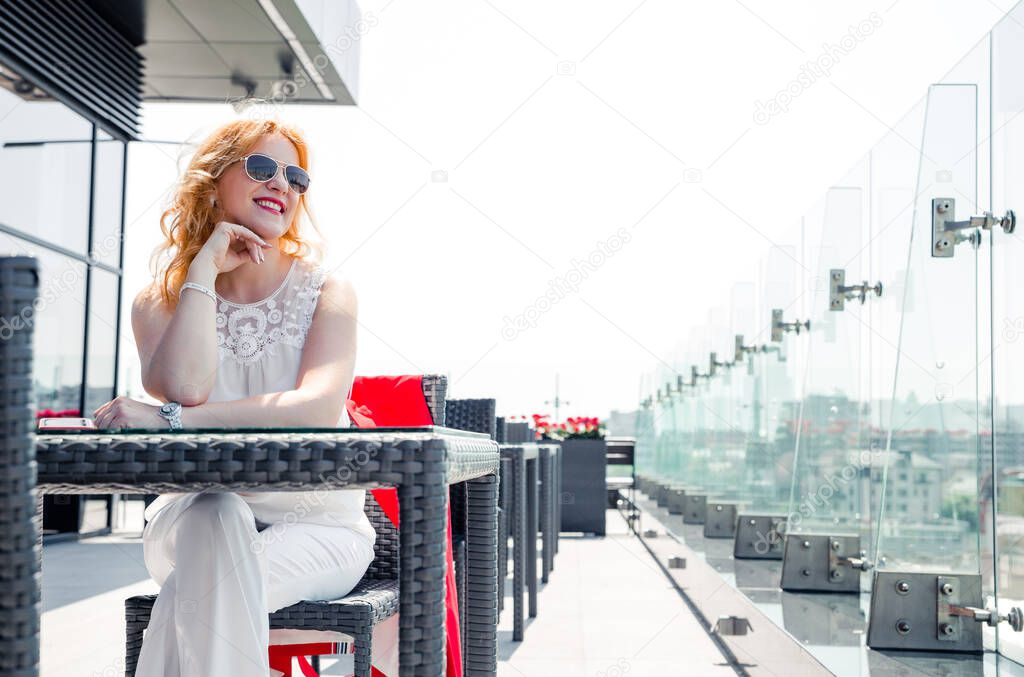 Portrait mature woman smiling enjoying a beautiful sunny day in a cafe outside. Copy space