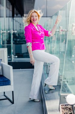 İş merkezindeki bir kafenin terasında poz veren mor ceketli başarılı bir girişimci kadın. İş kadını temsili konsepti