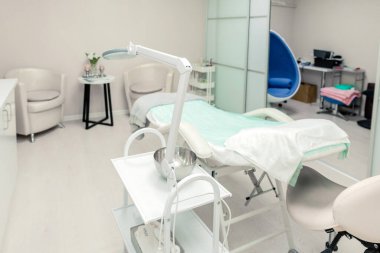 Modern bir güzellik salonunda kozmetik ve masaj masası olan kozmetik uzmanı boş bir ofis. Sağlık kabinesinin içi. Sağlık hizmetleri için modernize edilmiş kozmetik merkezi. 