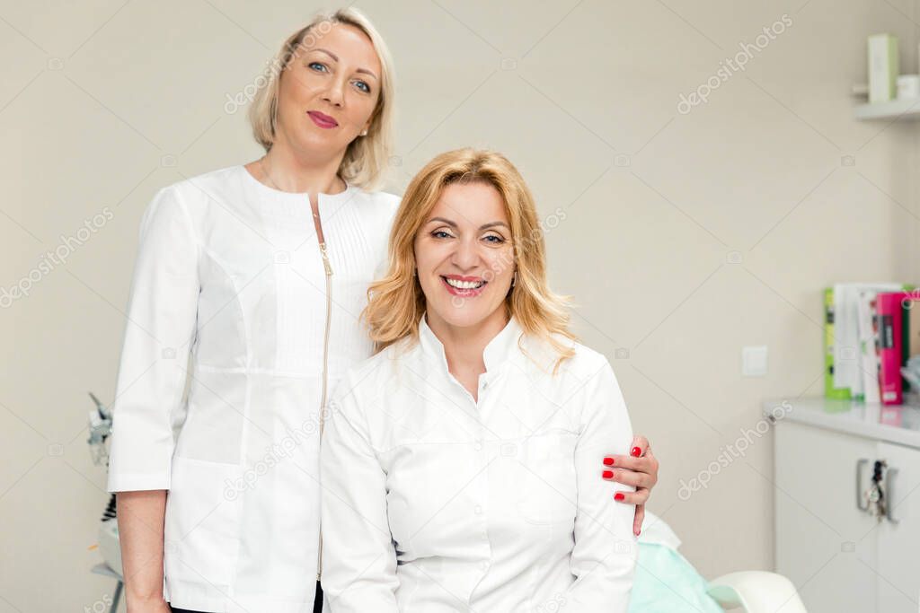 Two female doctor, friends and colleagues smiling and looking at the camera.Concept of female friendship