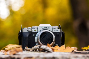 Fotoğraf ve video kamera Fujifilm sarı yaprakların arasında ve karşısında. Fotoğraf. Minsk, Belarus - 10 Ekim 2021