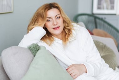 Sakin, gözleri kapalı bir kadın rahat koltukta dinleniyor, tembel boş vakitlerin tadını çıkarıyor, çekici, huzurlu, genç bir bayan dinleniyor, hayal kuruyor. Fotoğraf.