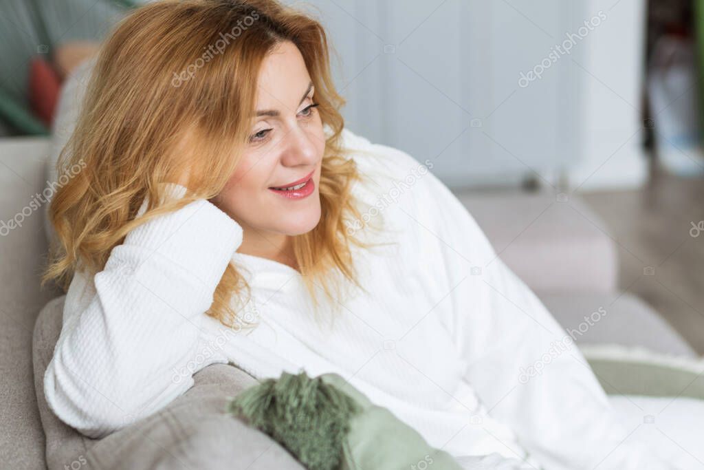 calm woman with closed eyes resting on cozy couch, enjoying lazy leisure time, attractive peaceful young female relaxing, daydreaming. Photo