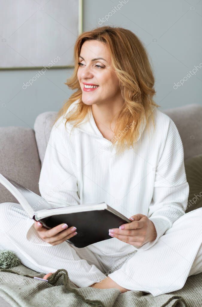 Woman sitting on couch and reading book. Social media detox. Slow living lifestyle. Mental wellbeing on quarantine. Happy female enjoying literature. Calm bookworm spending day off gadgets
